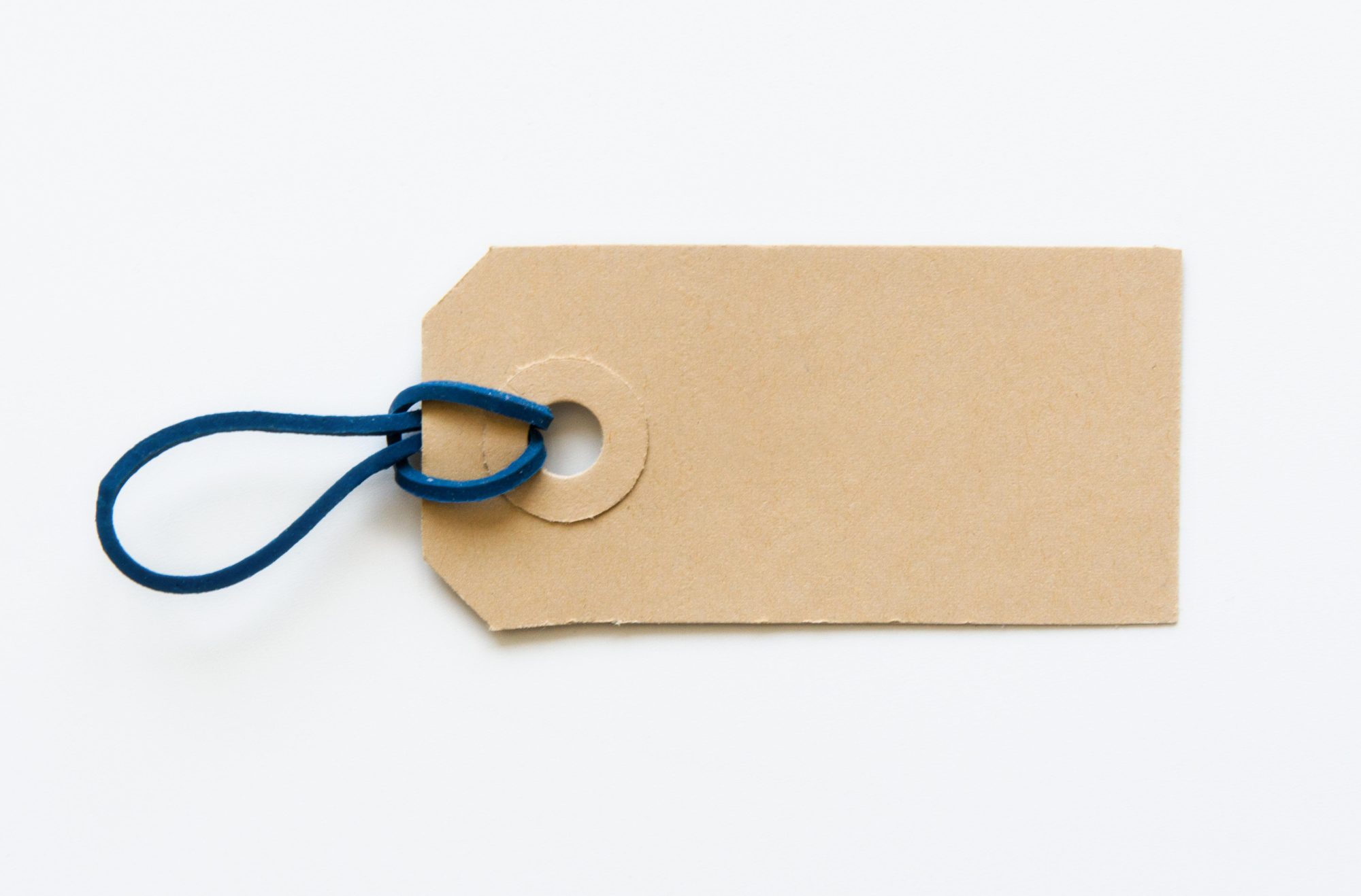 Een foto van een leeg, onbeschreven kartonnen label op een neutrale achtergrond.